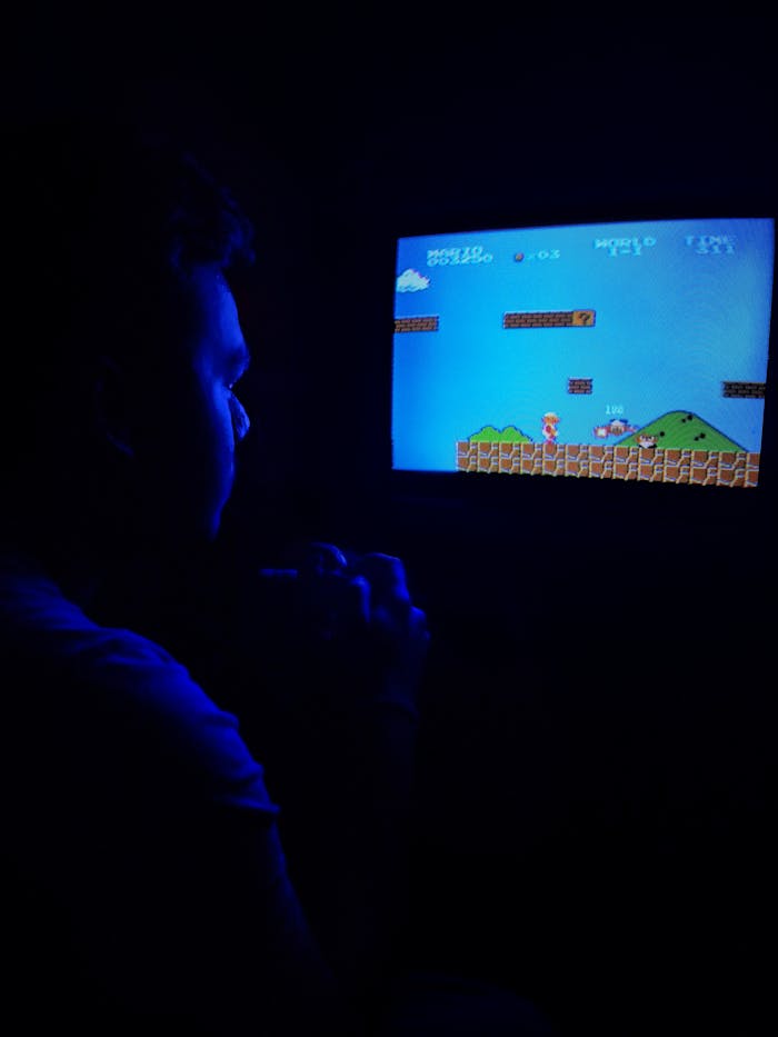 about-bg Man playing Super Mario Bros on TV, capturing retro gaming nostalgia.